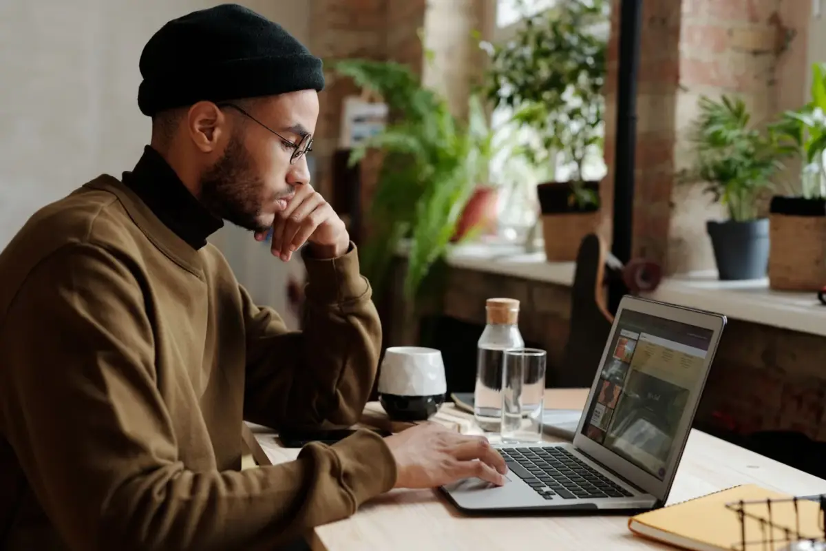 Freelancer working on a laptop at a desk by a window
