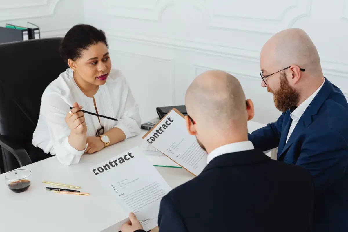 Three business professionals reviewing a contract together